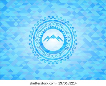 mountain icon inside light blue mosaic emblem