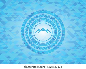 mountain icon inside light blue emblem with mosaic background
