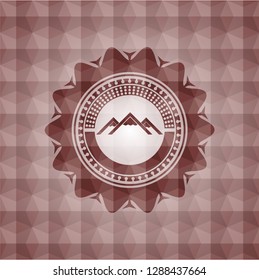 mountain icon inside red seamless emblem with geometric pattern.