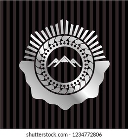 mountain icon inside silvery badge