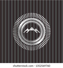 mountain icon inside silvery emblem