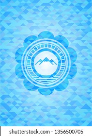 mountain icon inside sky blue emblem with mosaic background