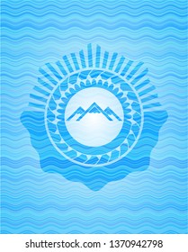mountain icon inside sky blue water wave emblem.