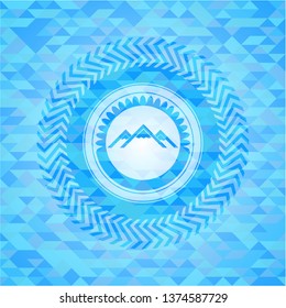 mountain icon inside sky blue emblem with mosaic background