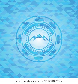 mountain icon inside sky blue emblem with mosaic background
