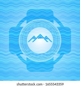 mountain icon inside water representation badge background.