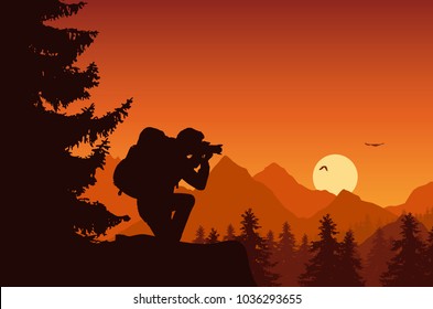 Mountain landscape with forest and tourist photographing flying birds on an orange sky with rising sun
