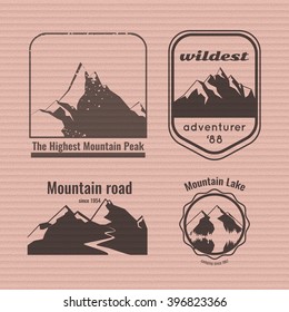 Mountain logo on the cardboard texture. Stock vector.