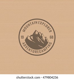 Mountain logo on the cardboard texture background. Stock vector.