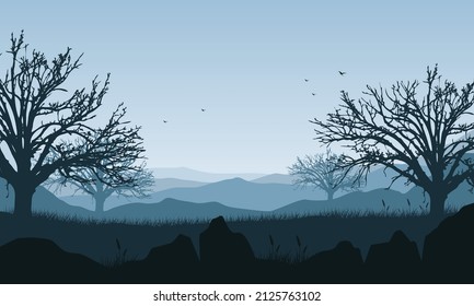 Mountain panorama with aesthetic dry tree silhouettes from the countryside when the sky is blue