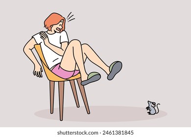 Mouse scares woman jumped onto chair out of fear and experiences musophobia at sight of rodent. Hysteria and panic in young girl who saw small mouse in house, causing awe and horror