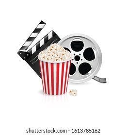 Movie Clapper Board, Popcorn in the Striped Bag and Film Reel Over White Background. Cinematography Movie Festival Concept