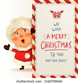 Mrs.Claus with big signboard. Merry Christmas calligraphy lettering design. Creative typography for holiday greeting.