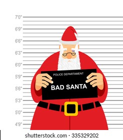 Mugshot is bad Santa. Arrested Santa Claus at  police station holding a sign. Christmas  offender in  bruise under eye. His grandfather was detained for fight.
