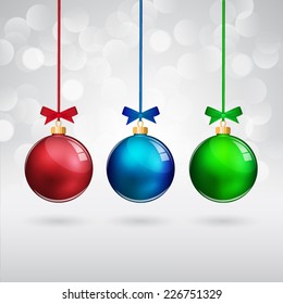 Multicolor christmas balls with bows on sparkling background.