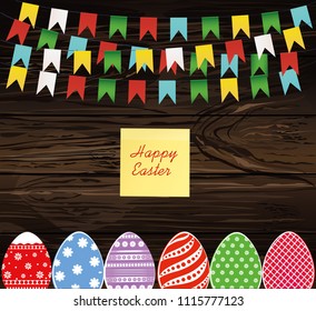 Multicolored decorated Easter eggs. Garland of flags. Bunting. Yellow sheet of paper for notes. Sticker. Greeting card or invitation for a holiday. Vector on wooden back. Empty space for text.