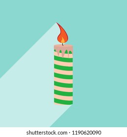 Multi-colored festive candle with smudges of wax, long shadow