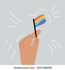 Mehrfarbige Flagge in der Hand. Eine kleine Fahne mit Regenbogenfarben