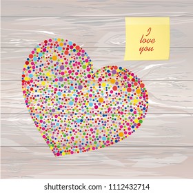 Multicolored rainbow confetti in the shape of a heart. Yellow sheet of paper for notes. Sticker.Vector on wooden background. Love. Postcard or invitation for a holiday. Valentine's Day.