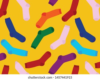 Multi-colored socks on a yellow background. View from above. Many different socks for cold seasons. Socks are scattered on a bright background. 