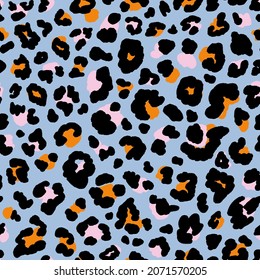 Multicolored wild animal skin seamless repeat pattern. Random placed, vector spots leopard all over surface print on blue background.