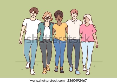 Multiracial people walk through park hugging and enjoying friendship with college classmates. Multiracial students walk together on grass and invite to become member of friendly university community
