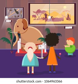 Museum. Scarecrow mammoth, plate with the history of the elephant. Children, two girls and a red guy who shows a finger on the exhibit. Primitive people and their belongings  wildlife. Modern flat 