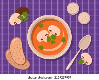 Mushroom soup puree with parsley on a plate. Cutlery, mushrooms, salt and pepper on a purple checkered background.