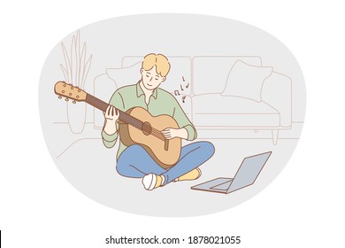 Music, playing guitar concept. Young boy sitting at home with guitar and learning to play online during distant lesson. Music festival, melody, song, hobby, entertainment, enjoy music 