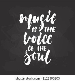 Music is the voice of the soul - hand drawn Musical lettering phrase isolated on the black chalkboard background. Fun brush chalk vector quote for banners, poster design, photo overlays.