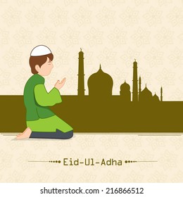 Muslim boy praying (Namaz, Islamic Prayer) in front of mosque on beige background for Eid-Ul-Adha festival celebrations. 