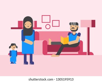 Muslim family A man lays on a sofa with a book, a woman in the hijab and his daughter is standing beside him.