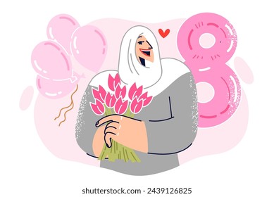 Muslim girl celebrates international women day holding bouquet of flowers in hand, stands near ball in shape of number 8. Female in islamic clothing receives congratulations on women day