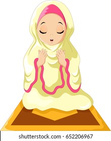 Muslim girl sitting on the prayer rug while praying