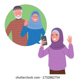 a Muslim girl wearing a hijab is doing a video call with her grandfather and grandmother via cell phone.