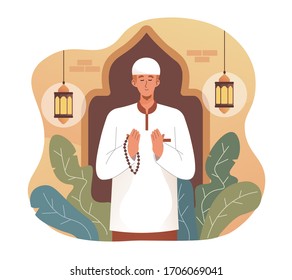 Muslim man praying while holding rosary beads