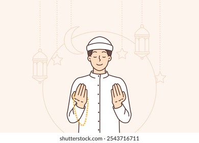 Muslim man prays to god and performs namaz, standing among islamic lanterns and crescents. Muslim guy in white religious clothes, doing holy ritual and reading prayer for Ramadan celebration