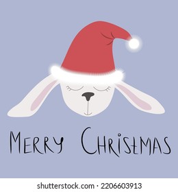 La boquilla de una pequeña liebre blanca o conejo en un sombrero de Santa con el texto feliz Navidad. Tarjeta de vacaciones, símbolo de 2023