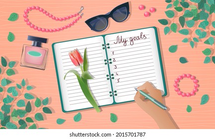 My goals concept with text on diary, planner or notebook with accessories. Elegant female desk and sunglasses, tulip, beads, bracelet, perfume and house plant  Planning, motivation hand writes.