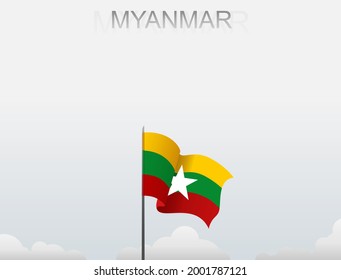 Myanmar flag fluttering on a pole standing tall under the white sky
