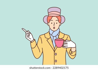 Mysterious man dressed as hatter from story Alice in Wonderland drinks tea and points finger to side. Mad hatter style guy is ready to go to theme party or carnival dedicated to children fairy tale 