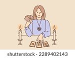 Mysterious woman with Tarot cards in form of gypsy witch sits at table and predicts future being fortune teller or clairvoyant. Girl fortuneteller with Tarot cards conducts esoteric session