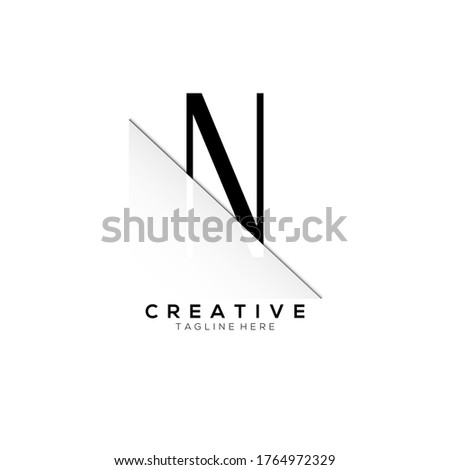 N Black Letter Logo Design with Creative Paper Cut Foto stock © 