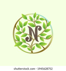 N letter logo made of twisted tree branches and green leaves in circle. Ecology vector font for vegan emblem, botanical identity, creative spring t-shirts, organic merchandise.