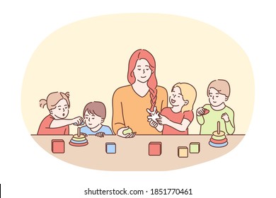 Nanny in kindergarten, babysitter, babysitting concept. Young smiling woman cartoon character babysitter or nanny playing with group of small children at table. Sister, mother, parenting 