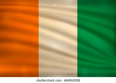 The national flag of Ivory Coast on wavy silk background with bokeh lights. Realistic vector illustration.