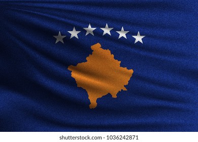 The national flag of Kosovo. The symbol of the state on wavy cotton fabric. Realistic vector illustration.