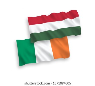 National vector fabric wave flags of Ireland and Hungary isolated on white background. 1 to 2 proportion.