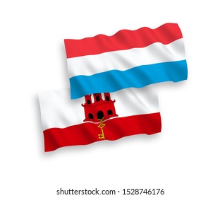 National vector fabric wave flags of Gibraltar and Luxembourg isolated on white background. 1 to 2 proportion.
