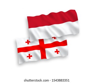 National vector fabric wave flags of Indonesia and Georgia isolated on white background. 1 to 2 proportion.